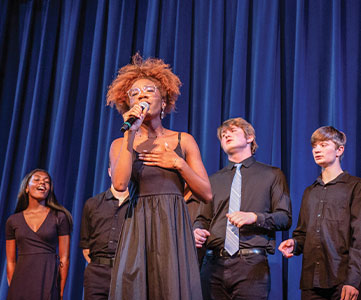 Choir group singing on stage. Links to Beneficiary Designations