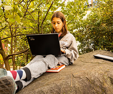 Student sitting on a rock. Links to Gifts from Retirement Plans